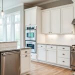 Modern kitchen featuring white cabinetry, stainless steel appliances, and hardwood flooring, showcasing a clean and inviting space ideal for interior painting services by Esteem Painting in Harrisburg, PA.